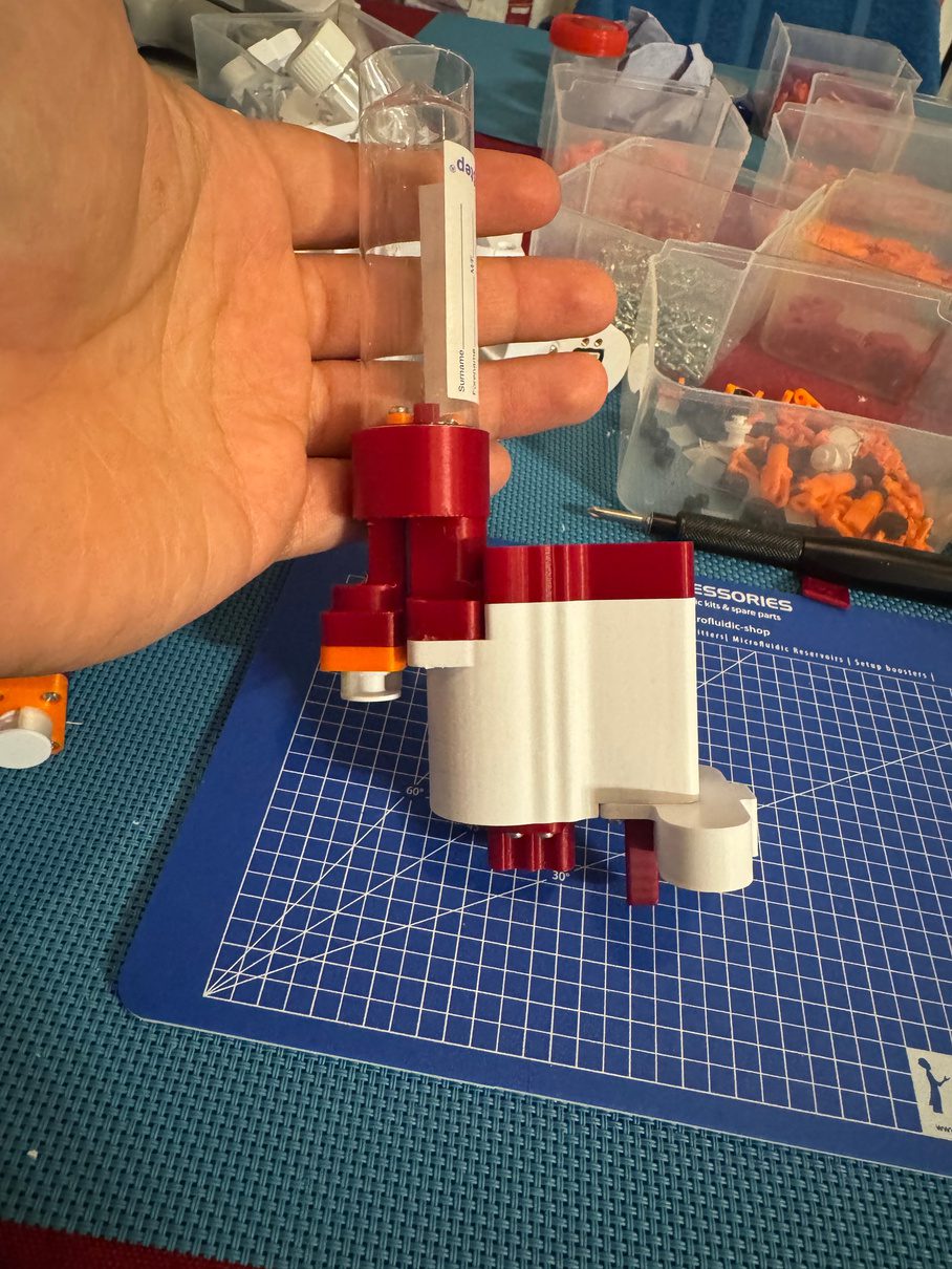 Prototype biotech sample cartridge held in a gloved hand