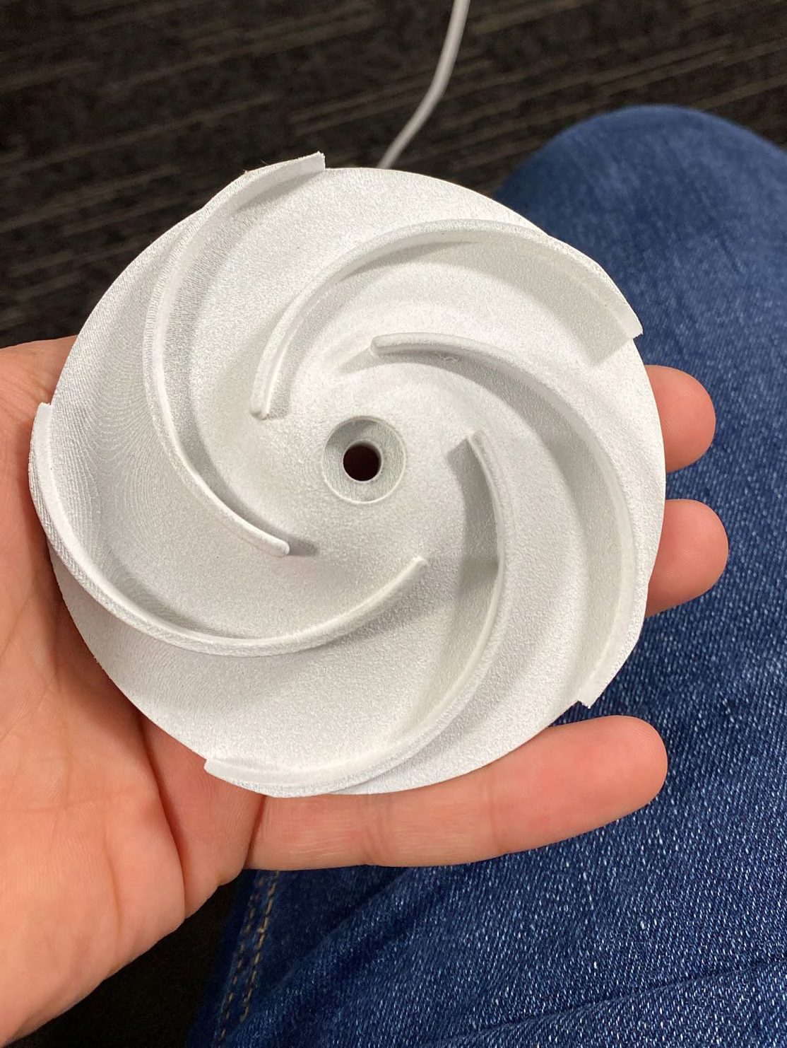 SLS 3D-printed titanium impeller prototype held in hand